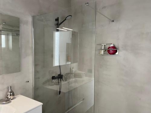 阿索马达Luxury studio, sea view, pool的一间带玻璃淋浴间和水槽的浴室