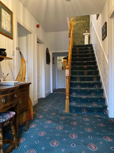 斯佩河畔格兰敦Garden Park Guest House的走廊,楼梯位于一座带钢琴的房子里
