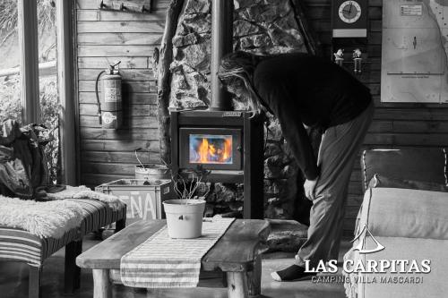 Villa MascardiLas Carpitas的站在一个房间里炉子前的人