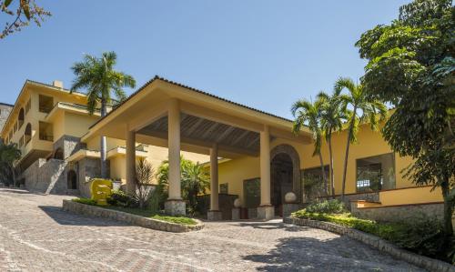 阿卡普尔科阿卡普尔科迪亚曼特卡米诺里尔酒店 的一座棕榈树的黄色建筑