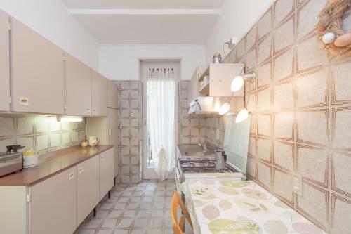 维罗纳焦亚公寓的厨房配有白色橱柜和台面