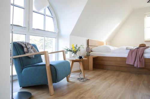 富伦多夫Holiday house, Fuhlendorf的一间卧室配有一张床和一张蓝色椅子