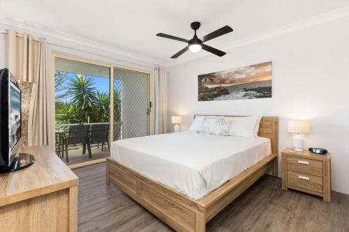 金斯克里福2Bed Beachfront Apartment - Holiday Management的一间卧室设有一张床、一台电视和一个阳台。