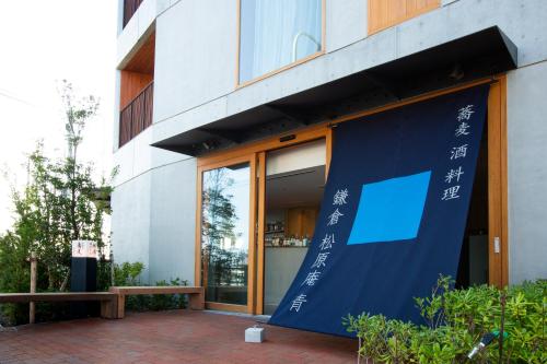 镰仓市HOTEL AO KAMAKURA的前面有蓝色横幅的建筑
