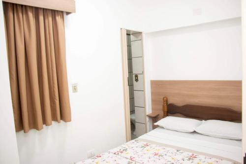 瓜鲁雅Hotel Morada do Mar的一间卧室设有一张床和一个窗口