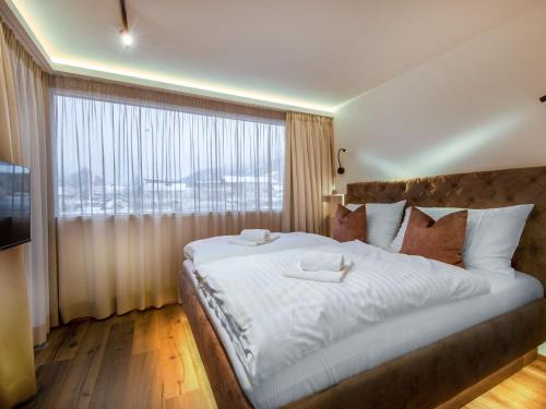 维尔德科格尔山麓布兰贝格Apartments B-HOME, Bramberg am Wildkogel的一间卧室设有一张大床和大窗户