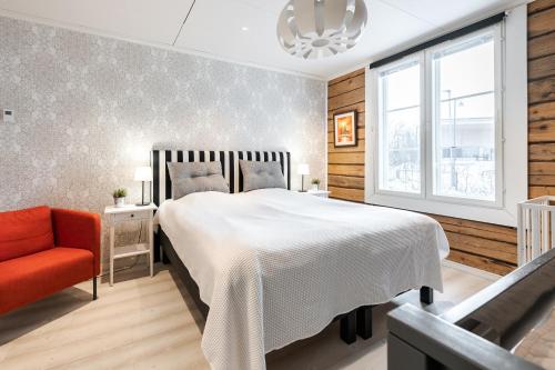 坦佩雷Villa Härmälä的卧室配有白色的床和红色椅子