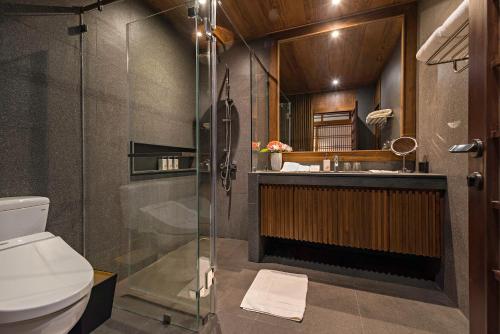 湄林蒙查温泉旅馆的带淋浴、盥洗盆和卫生间的浴室