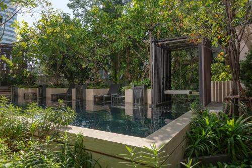 曼谷Gardina Asoke Hotel & Residence - SHA Certified的花园内的游泳池