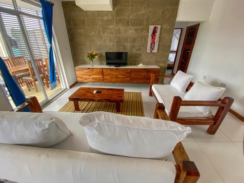 迪亚尼海滩Aqua Resort的客厅配有沙发、椅子和电视