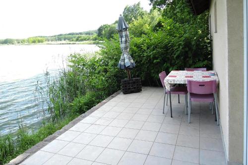 什切青Holiday House in Szczecin at the lake with parking space for 4 persons的庭院配有桌椅和遮阳伞。