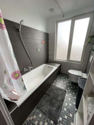 阿尔克马尔Comfortable Room的带浴缸和卫生间的浴室。