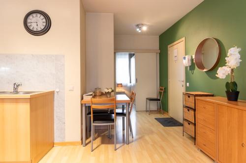 布鲁塞尔Cozy Apartment Brussels Centre的厨房以及带桌子和镜子的用餐室
