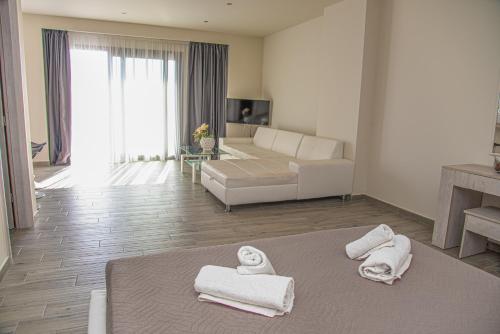 圣斯特凡诺斯Tereza's Sunset Hotel的客厅配有沙发和床上毛巾