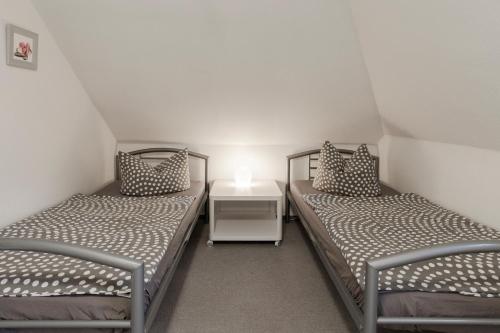 汉堡Ferienwohnung-Fuhlsbüttel-Hamburg的带床头柜的客房内的两张单人床