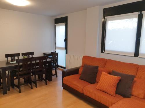 哈卡Apartamento Vive Jaca的带沙发的客厅和用餐室