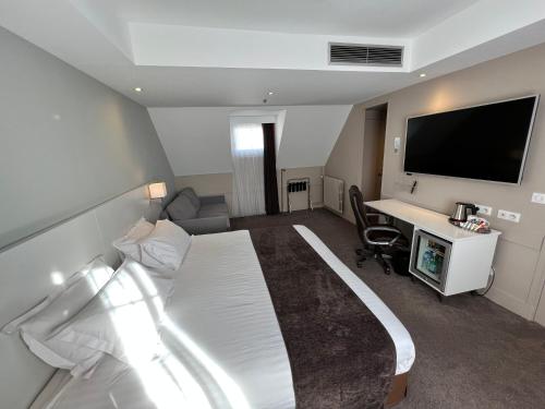 巴黎巴黎奥特伊智选假日酒店的酒店客房设有一张床、一张书桌和一台电视机。