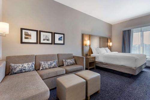 斯科茨Comfort Suites Scottsdale Talking Stick Entertainment District的酒店客房设有一张沙发和一张床