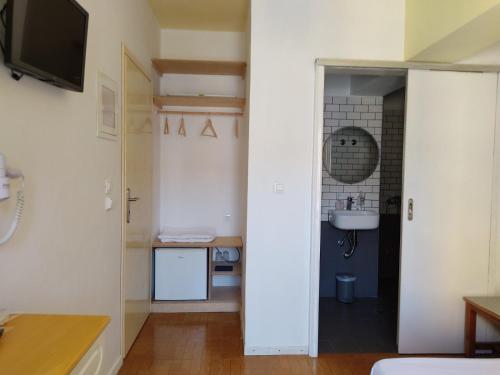 锡米阿纳斯塔西娅酒店的客房设有带水槽和镜子的浴室