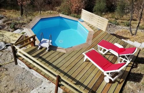 LucéramChalet sur pilotis avec piscine privée的一个带游泳池和两把椅子的甲板