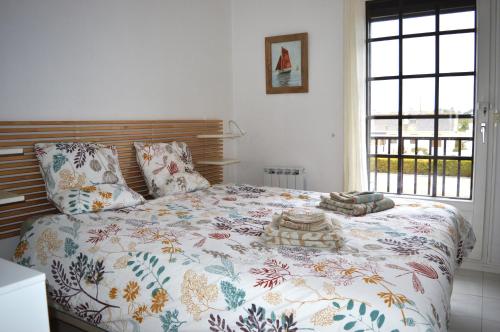 库尔瑟勒·苏尔·梅尔Triplex avec jardinet - wifi - à 400m de la plage的一间卧室配有一张带花卉棉被的床