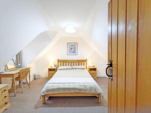 刘易斯Vane Cottage - Lewes的一间卧室配有一张床、一张书桌和一个楼梯