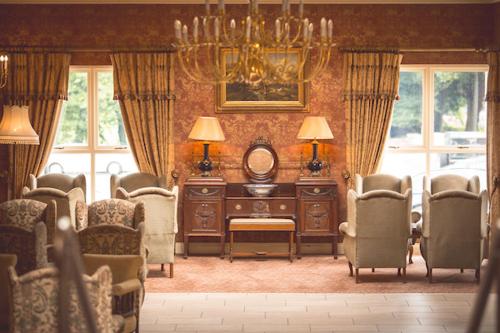 Clogher克奥利克之家酒店及水疗中心的客厅配有桌椅和吊灯。