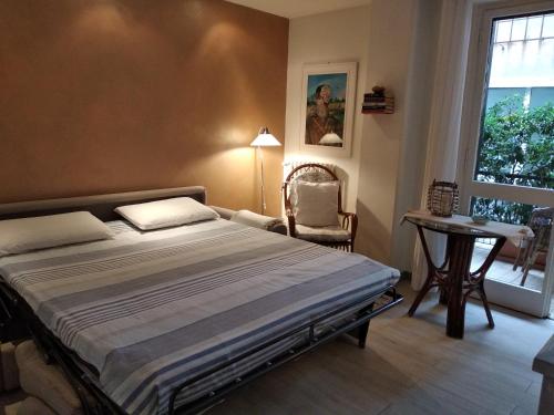 拉帕洛La Casetta - Near the sea & free parking的卧室配有床、椅子和窗户。