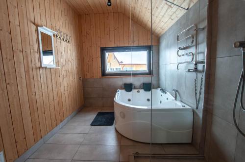 AntakalnisSodybos kompleksas - ECO Resort Trakai的带浴缸和窗户的大浴室