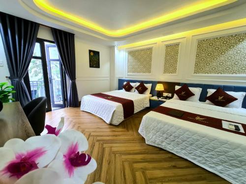 Cao LãnhTHƯ LÊ Hotel的一间酒店客房,配有两张床和鲜花