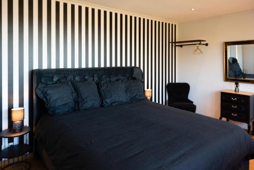 那慕尔Cocoon-Chambre d'Hôtes的一间卧室配有一张床和黑白条纹墙