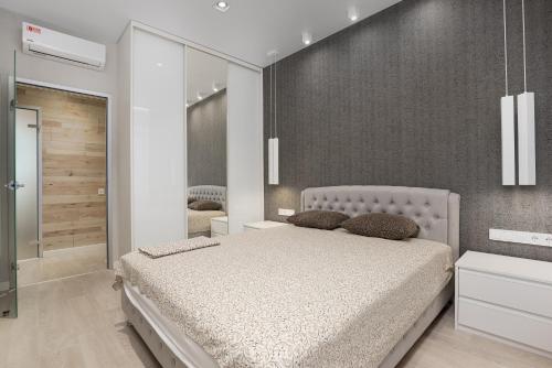敖德萨45 Pearl 2-bedrooms Apartment with Terrace的一间卧室配有一张大床和镜子