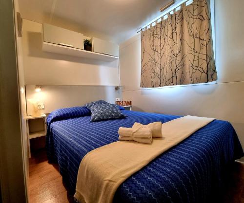 皮肖塔Villaggio Acquamarina的一间卧室配有蓝色的床和蓝色的毯子