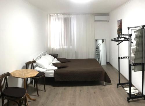 基辅Мини Отель «Positive”的一间卧室配有一张床和一张桌子及椅子