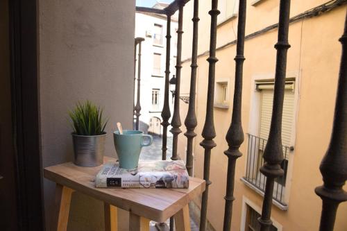 图德拉Apartamento Palacio Descalzos的阳台上的桌子和杯子