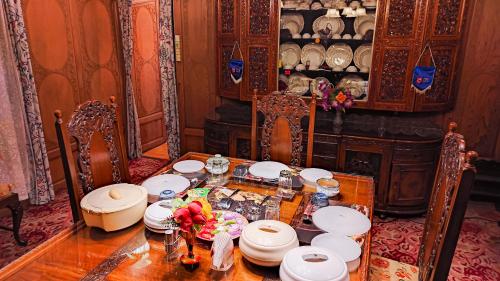 斯利那加Dal Lake Heritage Houseboat New Manila的用餐室,配有带盘子和鲜花的桌子