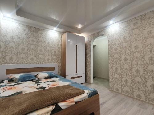 加格拉Квартира的壁纸客房内的一间卧室配有一张床