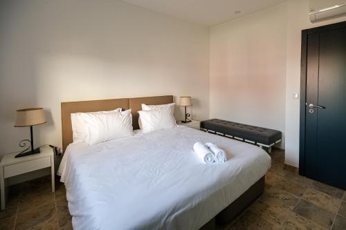 Vale de SantarémQR Casas de Campo的一间卧室配有一张带白色床单的大床