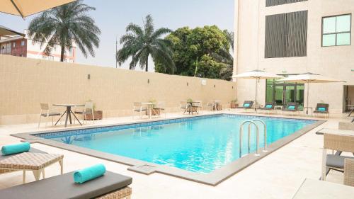 雅温得STAR LAND HOTEL BASTOS的酒店设有带桌椅的游泳池