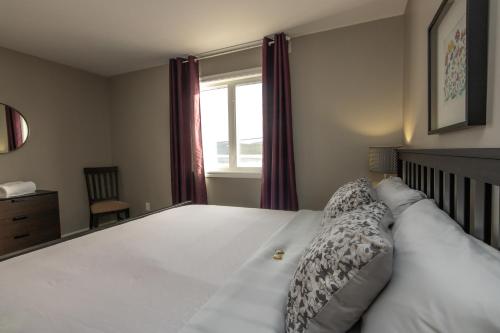 Arnold's CoveThe Killick Inn & Suites的卧室配有一张大白色床和窗户