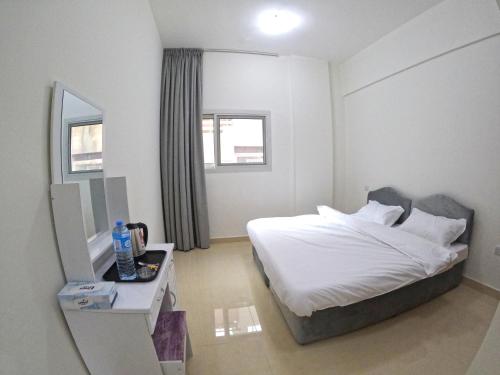 迪拜Karama Star Residence (Home Stay)的一间卧室配有一张床、一张桌子和一面镜子