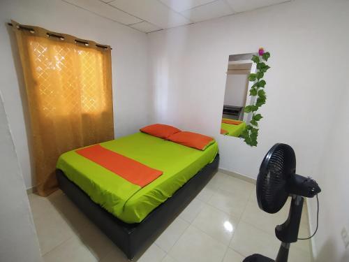 里奥阿查Apartamento #3 completo en excelente ubicación的一间卧室配有一张带绿色和红色床单的床