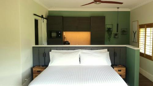 巴林布莱克伍德山谷套房住宿加早餐旅馆的一间卧室设有一张白色的床、绿色的墙壁和天花板