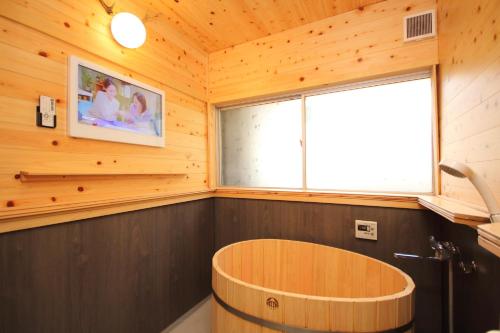 富士河口湖Fuji Time Traveler的木制客房设有大窗户和木制浴缸。