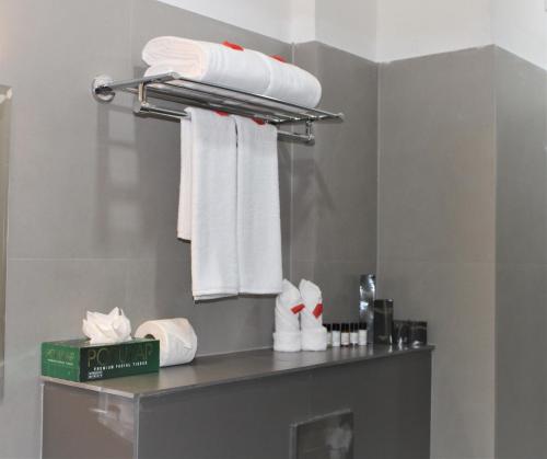 卡尔佩特塔SATRA WAYANAD的架子上配有白色毛巾的浴室