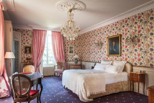 勒鲁雷恩阿皮涅城堡酒店的一间卧室配有一张床和一个吊灯