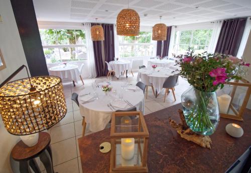 米米藏Hotel Au Bon Coin du Lac的一间设有白色桌子和花瓶的用餐室