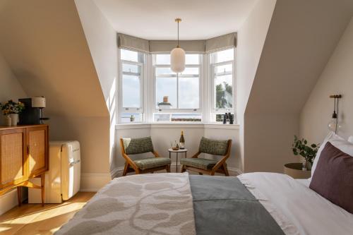 CulrossThe Dundonald Guesthouse & Cottage的一间卧室配有一张床、两把椅子和一个窗户