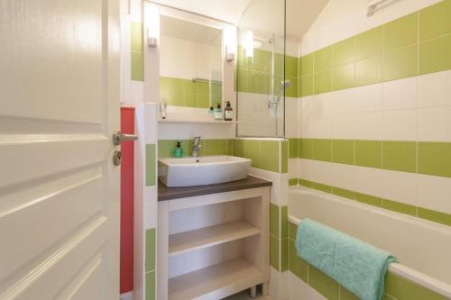 布朗维尔l'appartement la Pommeraie的一间带水槽、浴缸和镜子的浴室
