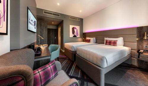迪拜Premier Inn Dubai Barsha Heights的酒店客房,设有两张床和一张沙发